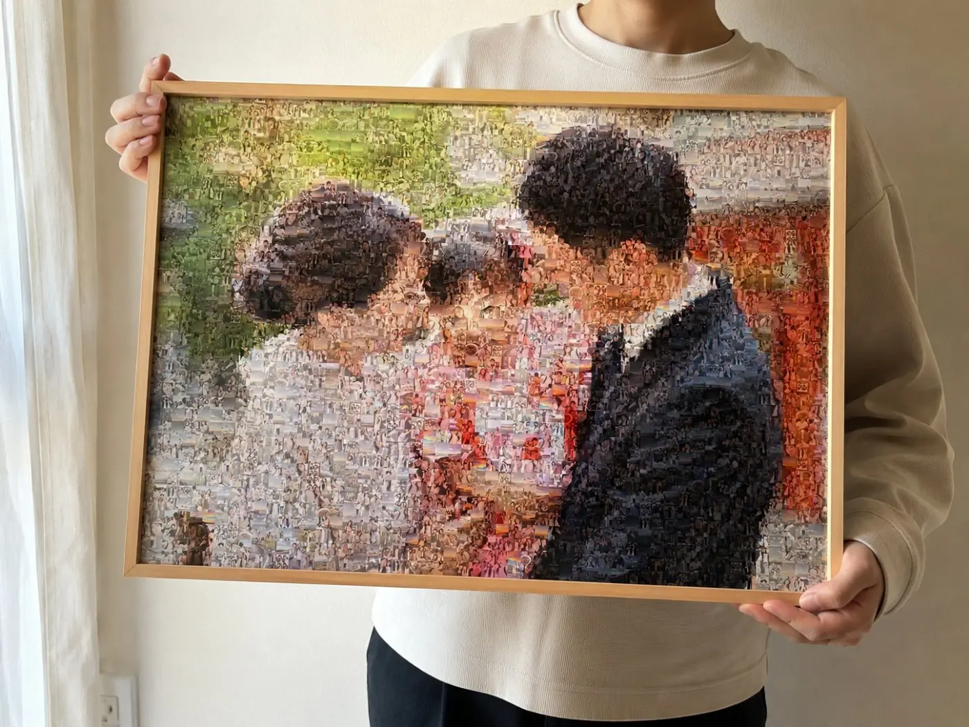 額装された作品を手に持っているところ